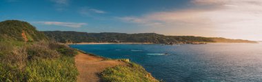 Mazunte, Oaxaca, Meksika. Güneş doğarken Punta Cometa 'dan Playa Del Lalo' nun görüntüsü. Dikilmiş panorama.