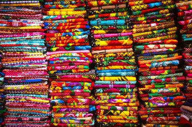 Yığınla huipiles, Oaxaca, Meksika 'dan geleneksel kadın elbiseleri. Juchitan, Oaxaca 'daki bir marketten renkli tekstil.