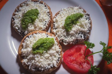 Picaditas Acapulquenas. Üstünde yeniden kızartılmış siyah fasulye, taze cotija peyniri ve çiğ salsa verdesiyle mısır lapası..