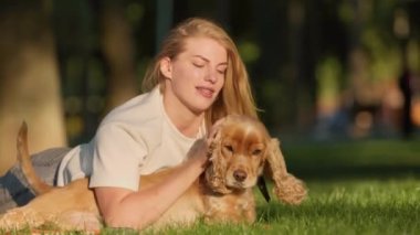 Genç Kadın Şehir Parkı 'ndaki çimlerde İngiliz Cocker Spaniel Köpeğiyle Oynuyor ve Eğleniyor. Evcil hayvanıyla gezen Çekici Kız