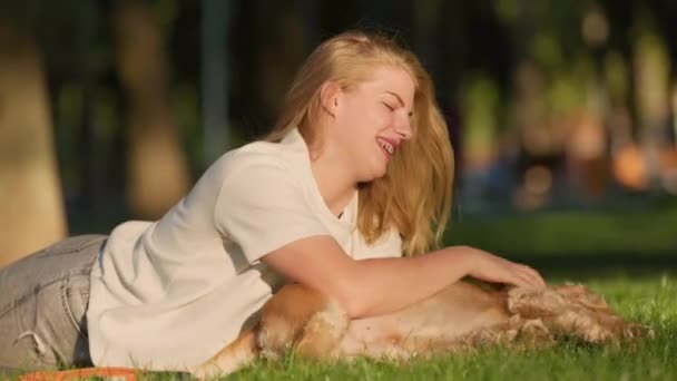 若い女性は シティパークで芝生に彼女の英語のコッカー スパニエル ドッグと遊んで楽しいを持っています 魅力的な ガール ウォーキング ととも 彼女の ペット — ストック動画