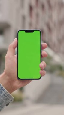 Dışarıdaki Adam Yeşil Model Ekran Telefonu Kullanıyor. Guy Scrolls ve Touches on Chroma Key Explay, News and Scrolls aracılığıyla Smartphone. Dikey Video