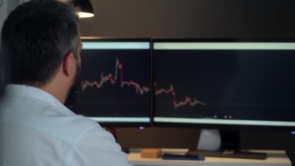 Trader Masculino Olha Para Gráficos Negociação Monitores Computador Desktop — Vídeo de Stock