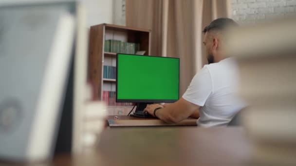 男人坐在办公室的办公桌前 在台式机上用绿色模拟屏幕工作 Chroma键显示 — 图库视频影像