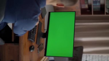 Man Ofis Masasında Oturuyor ve Yeşil Model Ekranlı Masaüstü Bilgisayarı 'nda Çalışıyor. Krom Anahtar Ekranı 'nın yakın plan görüntüsü. Omzunun üstünden.