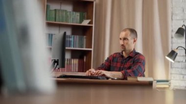 Ofiste oturan Genç Adam Masaüstü Bilgisayarını Kullanıyor