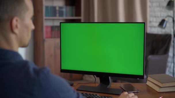 男人坐在办公室的办公桌前 在台式机上用绿色模拟屏幕工作 Chroma键显示的特写 超过肩膀中弹 — 图库视频影像