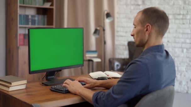 年轻人坐在办公室的办公桌前 在有绿色模拟屏幕的台式机上工作 Chroma键显示 — 图库视频影像