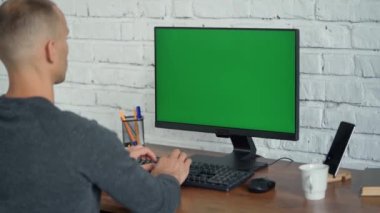 Klavyede Yazan ve Yeşil Ekran Bilgisayarına Bakan Adam. Ekranda Krom Tuş
