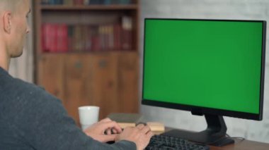  Klavyede Yazan ve Yeşil Ekran Bilgisayarına Bakan Adam. Ekranda Krom Tuş