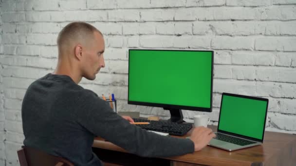在办公室有绿色屏风的台式机和笔记本电脑上工作 电脑和笔记本电脑上的色键显示 — 图库视频影像