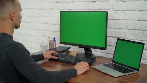 在办公室有绿色屏风的台式机和笔记本电脑上工作 电脑和笔记本电脑上的色键显示 — 图库视频影像