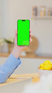 Dikey Ekran. Yeşil Ekran Mock Up Ekranı ile Akıllı Telefondan Kadın Eller Kaydırma Kaydırma Kaydırma Kaydırma Kaydırağı. Ev Mutfağındaki Kadın Mobil Cihazda Sosyal Medya İzliyor