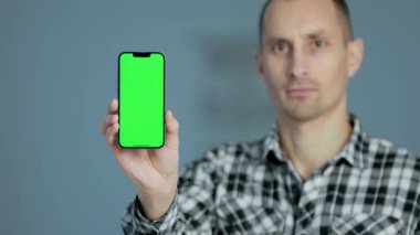 Genç Adam Yeşil Mock Up Ekranı ile Akıllı Telefon Gösteriyor