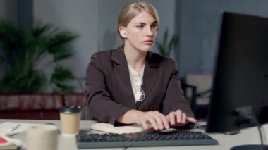 Masaüstü bilgisayarında çalışan ve not defterine not alan bir kadın. İş Kadını Çevrimiçi İnternet Tarayıcı ve Araştırma İşletmelerine Bakıyor