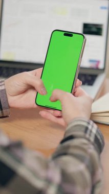 Dikey Yeşil Ekranlı Cep Telefonunun Kadın Ellerinde Yakın Çekimi. Kız Ofiste ya da Evde Akıllı Telefon Kullanıyor