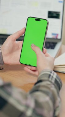 Dikey Yeşil Ekranlı Cep Telefonunun Kadın Ellerinde Yakın Çekimi. Kız Ofiste ya da Evde Akıllı Telefon Kullanıyor