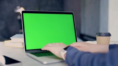 Yeşil ekranlı dizüstü bilgisayarla çalışan serbest çalışan birinin yakın çekimi. Chroma Anahtarı Dizüstü bilgisayarı. Bilgisayarda İzleme Defterini Kullanan Kadın Web sitesinde Kaydırıyor