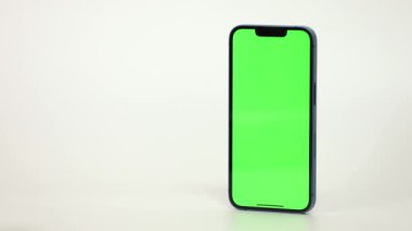 Cep Telefonu 'nun Kapanışı ve Beyaz Arkaplanda Yeşil Model Ekranı. Çırpınan adam, kaydıran jestler. İnternet Sosyal Ağ Tarama Haberleri, Mali Raporlar
