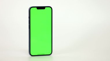 Cep Telefonu 'nun Kapanışı ve Beyaz Arkaplanda Yeşil Model Ekranı. Çırpınan adam, kaydıran jestler. İnternet Sosyal Ağ Tarama Haberleri, Mali Raporlar