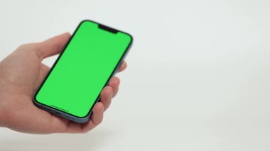 Cep Telefonu 'nun Kapanışı ve Beyaz Arkaplanda Yeşil Model Ekranı. Çırpınan adam, kaydıran jestler. İnternet Sosyal Ağ Tarama Haberleri, Mali Raporlar
