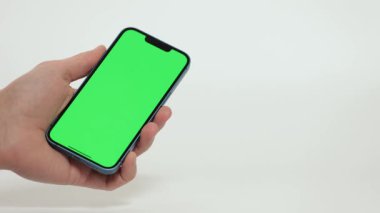 Cep Telefonu 'nun Kapanışı ve Beyaz Arkaplanda Yeşil Model Ekranı. Çırpınan adam, kaydıran jestler. İnternet Sosyal Ağ Tarama Haberleri, Mali Raporlar