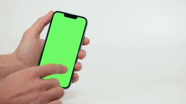 Cep Telefonu 'nun Kapanışı ve Beyaz Arkaplanda Yeşil Model Ekranı. Çırpınan adam, kaydıran jestler. İnternet Sosyal Ağ Tarama Haberleri, Mali Raporlar