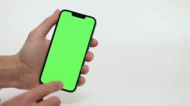 Cep Telefonu 'nun Kapanışı ve Beyaz Arkaplanda Yeşil Model Ekranı. Çırpınan adam, kaydıran jestler. İnternet Sosyal Ağ Tarama Haberleri, Mali Raporlar