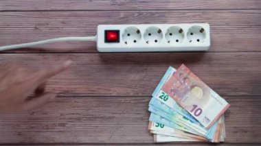 Mans, uzatma kablosundaki güç düğmesine elle basıyor. Ev için elektrik kablosu uzatma kablosundaki güç düğmesi. Ev anahtarı olan güç şeridi