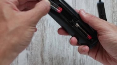 Evdeki TV kumandasına yeni pil takıyorum.