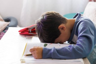 Çocuk evde ödevini yapıyor, yatay olarak.