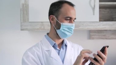 Doctor with mask using mobile, hospital