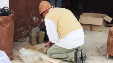 Potter preparing block of clay outdoors