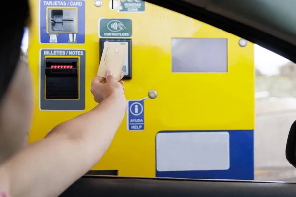 stock image Woman paying with a bank card a highway toll at an ATM through the car window