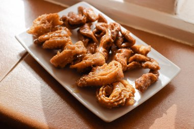  Bitkilerle dolu bir terasta beyaz bir tabakta Fas Chebakias