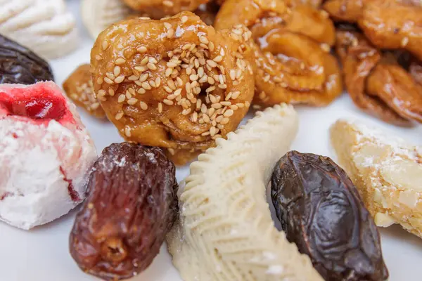 Assortment of chebakias, Moorish pasta and dates, on a white plate, at home