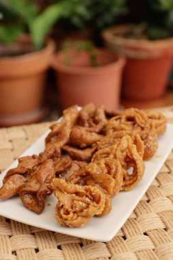 Fas Chebakias 'ı beyaz bir tabakta, bitkilerle dolu bir avluda, evde