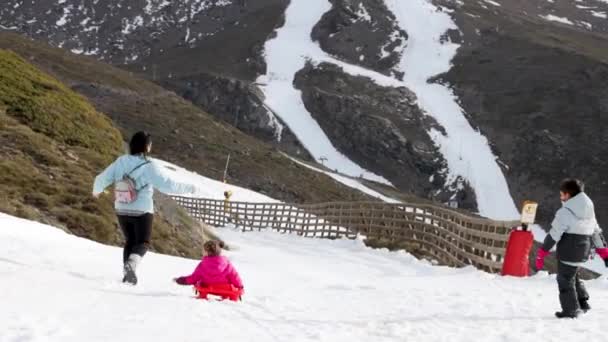 ソリで雪の中で遊ぶ家族 — ストック動画