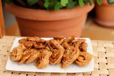 Fas Chebakias 'ı beyaz bir tabakta, bitkilerle dolu bir avluda, evde