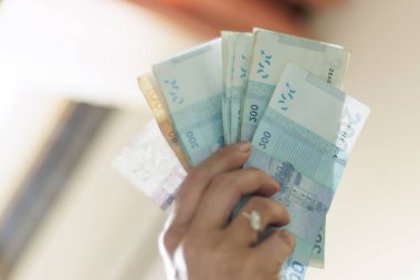 El ele tutuşan Fas banknotları, Dirham resmi Fas para birimi..