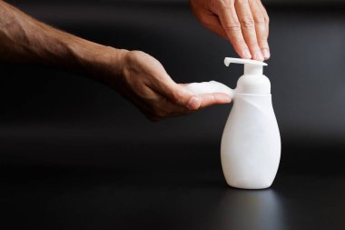 Bir el bir şişe sabun tutuyor..