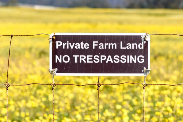 stock image Private Farm Land No Trespassing sign posted on a barbed wire fence.