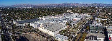 Aerial panoramic view of Westfield Valley Fair shopping center and surrounding residential area with a distant view of scenic mountains - San Jose, California, USA - September 27, 2024 clipart