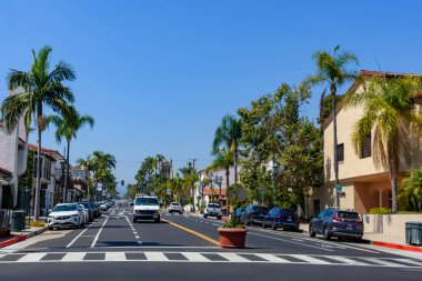 Palmiye ağaçları, İspanyol tarzı binalar, yaya geçidi, park edilmiş arabalar ve trafik manzarası. - Santa Barbara, Kaliforniya, ABD - 27 Ağustos 2024