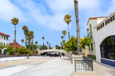 101. Otoyol 'un altındaki State Caddesi' nde palmiye ağaçları, yayalar ve gökyüzünün altında bir bisikletçi var. - Santa Barbara, Kaliforniya, ABD - 27 Ağustos 2024