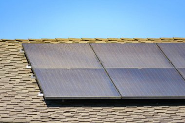 Kirli güneş panelleri asfalt kiremitli meskun bir çatıya monte edildi.