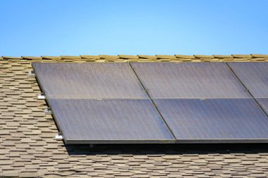 Kirli güneş panelleri asfalt kiremitli meskun bir çatıya monte edildi.