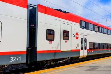İstasyon peronundaki Caltrain elektrikli tren vagonunun yan görüntüsü, acil erişim levhası ve bisiklet dostu kapılar - San Jose, California, ABD - 15 Eylül 2024