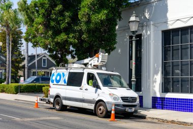 Cox İletişim servis minibüsü caddeye park edilmiş. Güvenlik konileri tedbirli olmak için yakınlara yerleştirilir. Ön cephe - Santa Barbara, California, ABD - 27 Ağustos 2024