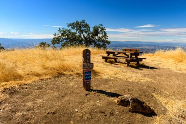 A scenic overlook in Joseph D. Grant County Park, with a picnic table and trail sign marking the 2,457-foot elevation with panoramic views of Silicon Valley clipart